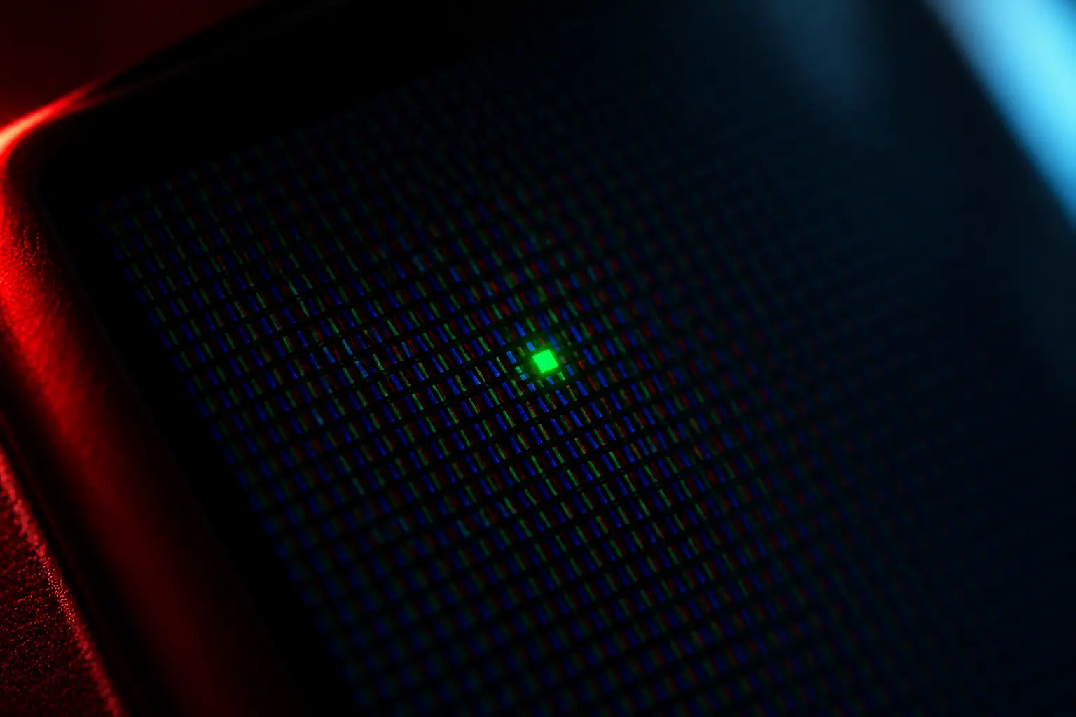 A laptop screen displaying a solid color test pattern with a single bright stuck pixel visible