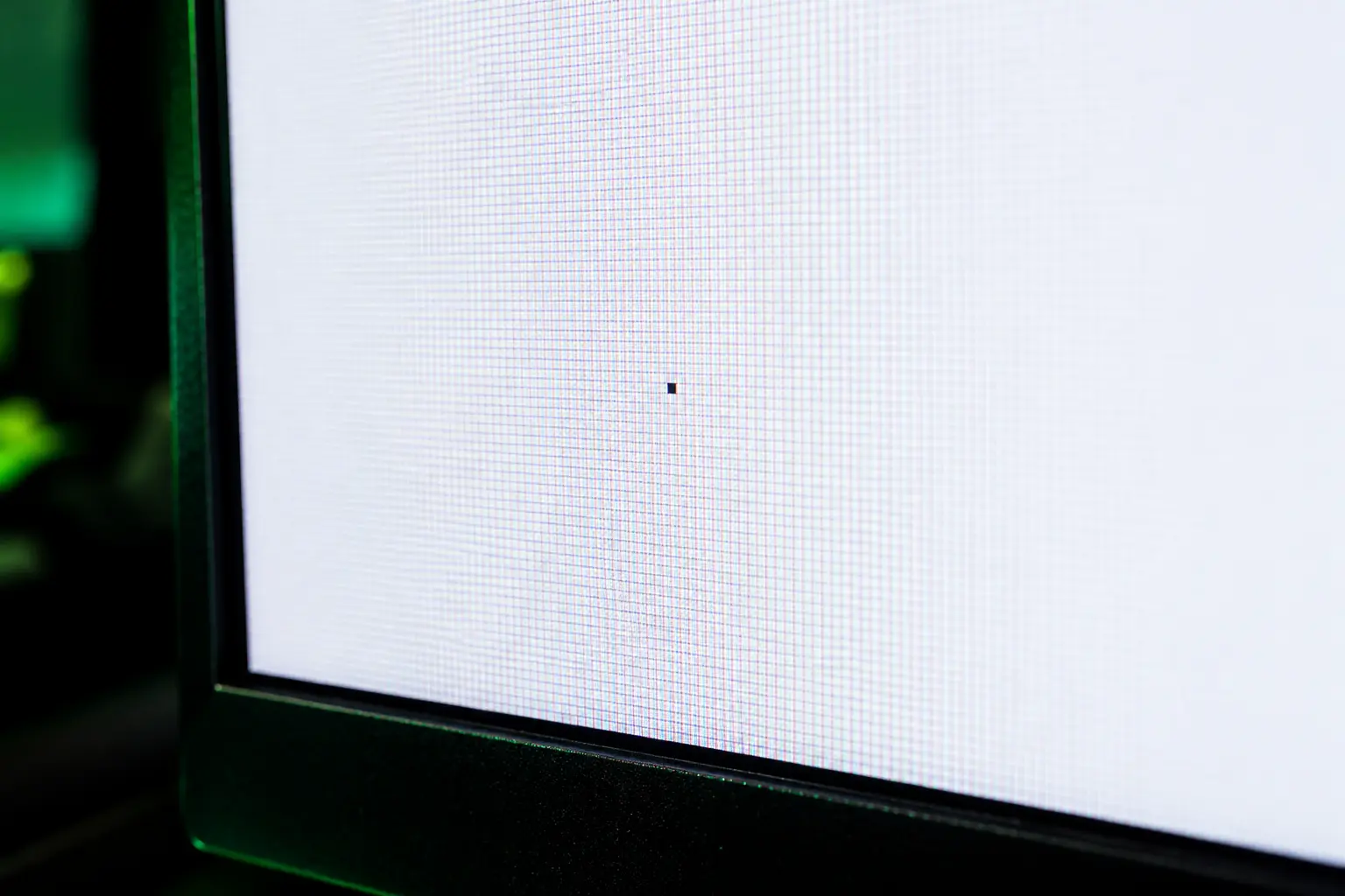 A used monitor displaying a white screen to reveal dead pixels during a test